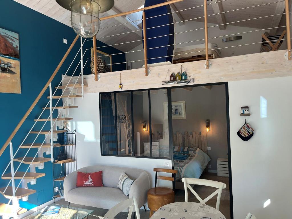 a living room with blue walls and a staircase at La cabane de Lily - T2 classé 3 étoiles in Rochefort