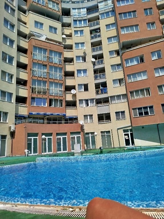 a swimming pool in front of some apartment buildings at Milushevi apartment in Golden Sands