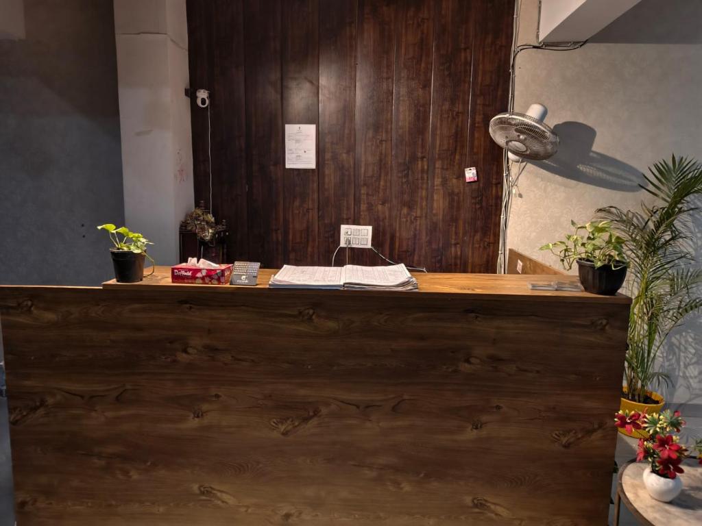 un mostrador de madera con macetas encima en Hotel Stayzzy Bloom, en Noida