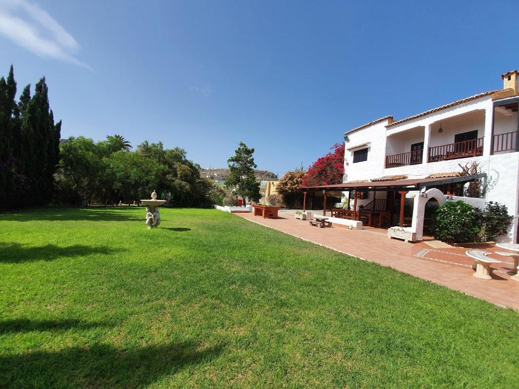 a large yard with a building and a park at Hacienda in Moya