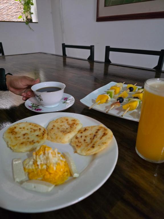 a table with two plates of food and a glass of orange juice at Casa ALCATRAZ in Cartagena de Indias