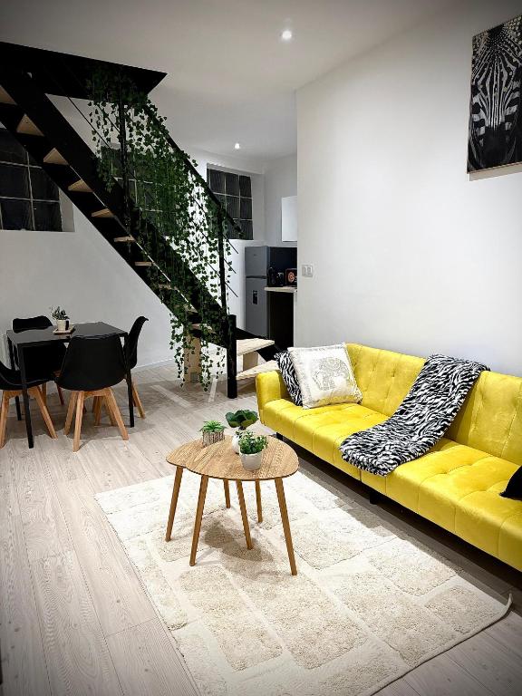 a living room with a yellow couch and a table at Écrin de Roye in Roye