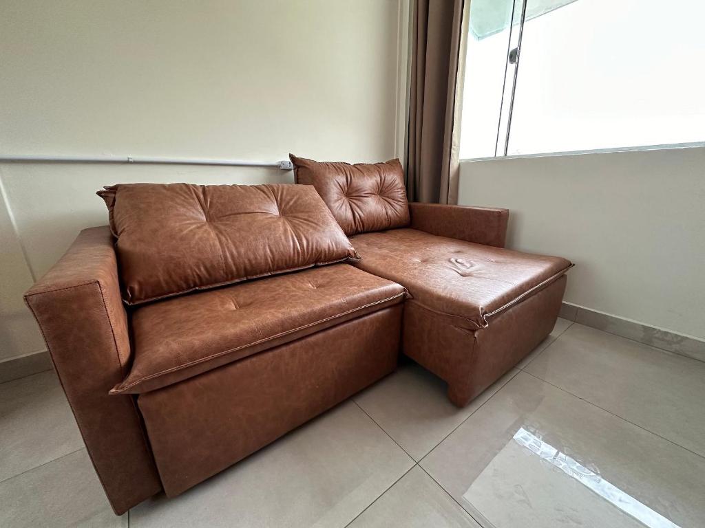 グァラトゥバにあるFlamingo Pé na areia - Centro/Guaratubaの窓際に座る茶色の革張りの椅子