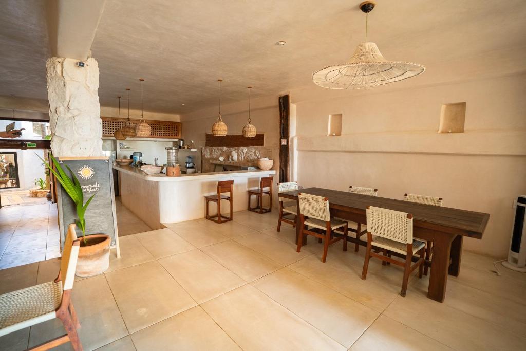 a kitchen and dining room with a table and chairs at La Posada del Sol Boutique Hotel Tulum in Tulum