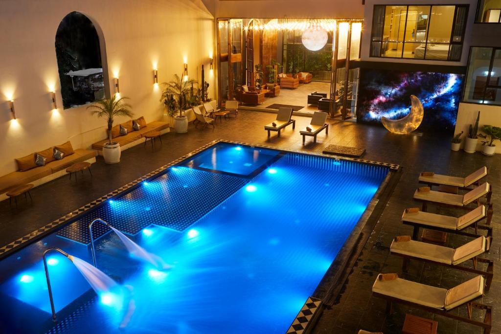 a swimming pool with blue lights in a building at Beston Pattaya - SHA Plus Certified in Pattaya South