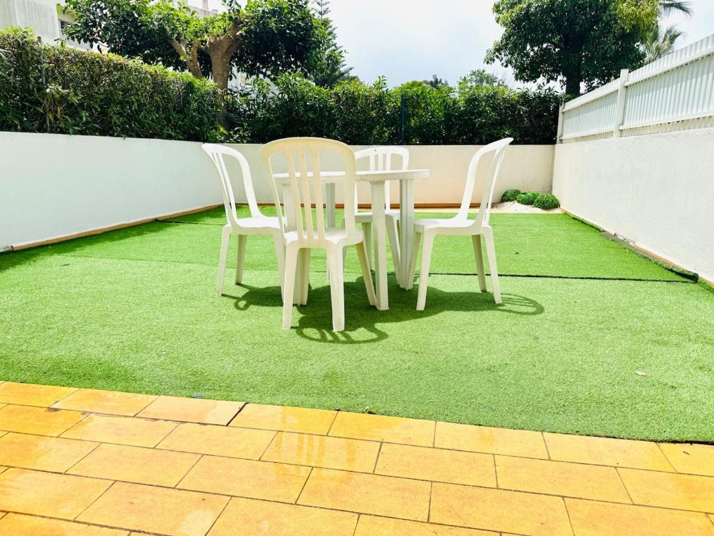 a table and two chairs sitting on a lawn at Apartamento gourmet com quintal in Albufeira