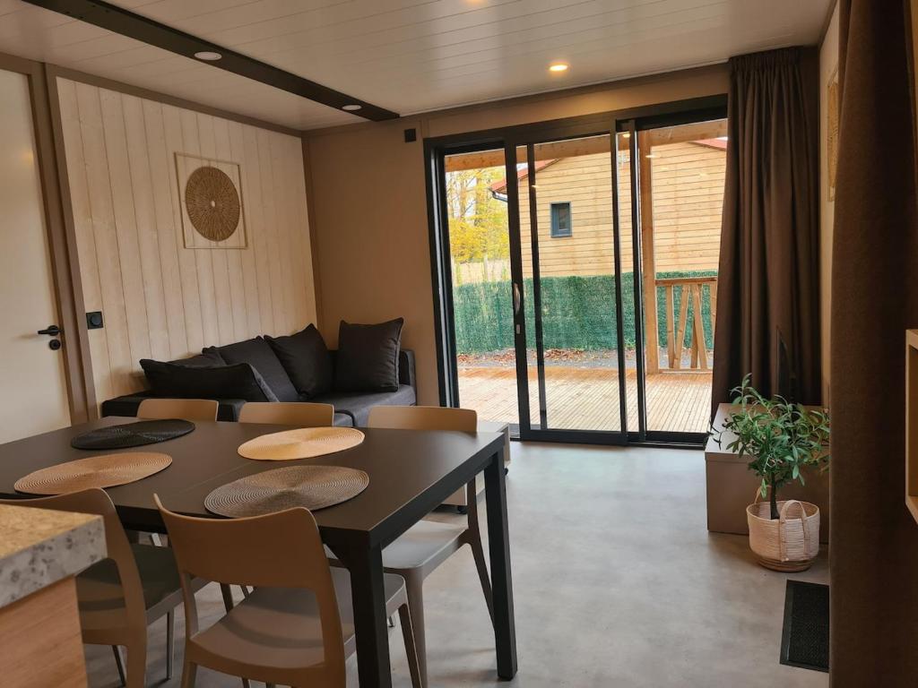 a living room with a table and chairs and a couch at Chalet Lac du Der Giffaumont-Champaubert in Giffaumont-Champaubert