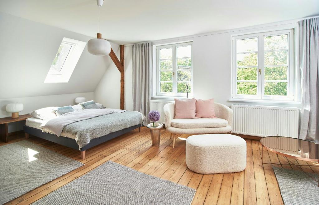 une chambre avec un lit et une chaise dans l'établissement Stylish Apartment In A Historic Country House, à Meezen