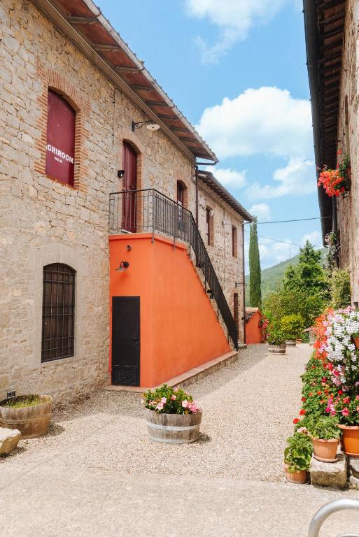a building with an orange door and a balcony at RICASOLI, Brolio Agriroom in Gaiole in Chianti