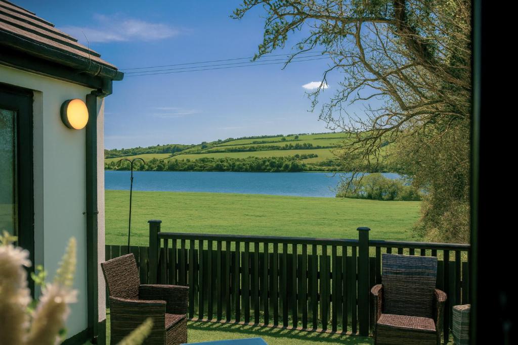 - une terrasse couverte avec 2 chaises et une vue sur le lac dans l'établissement Foyle View Retreat, à New Buildings