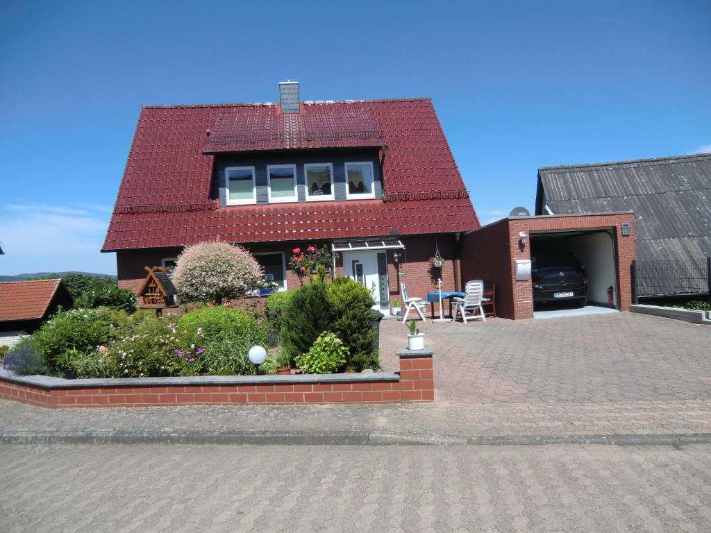 ein Haus mit rotem Dach und einer Ziegelsteinfahrt in der Unterkunft Ferienwohnung Landidyll in Hameln