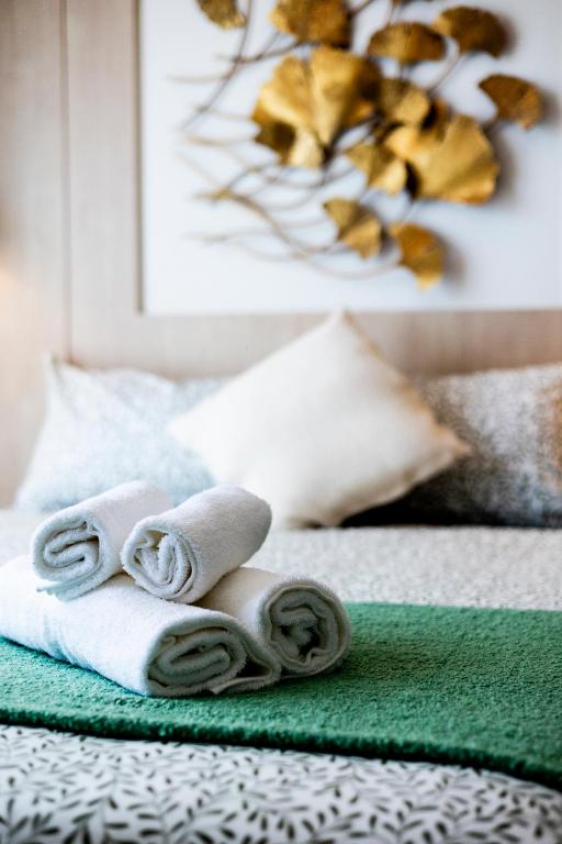 two pictures of towels on top of a bed at Premium 2BR near Kamala Beach, Pool, Gym & Shuttle Bus in Phuket
