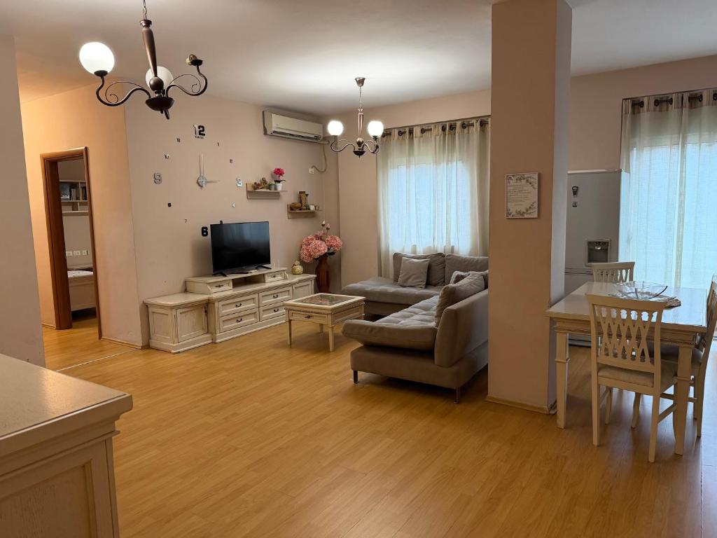 un salon avec un canapé et une télévision dans l'établissement Urban Apartment, à Tirana
