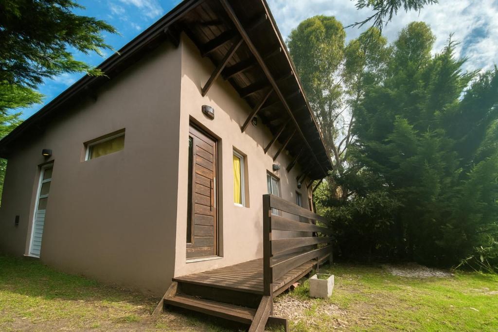 a small house with a porch and a door at Cabañas Cruz del Sur in Miramar