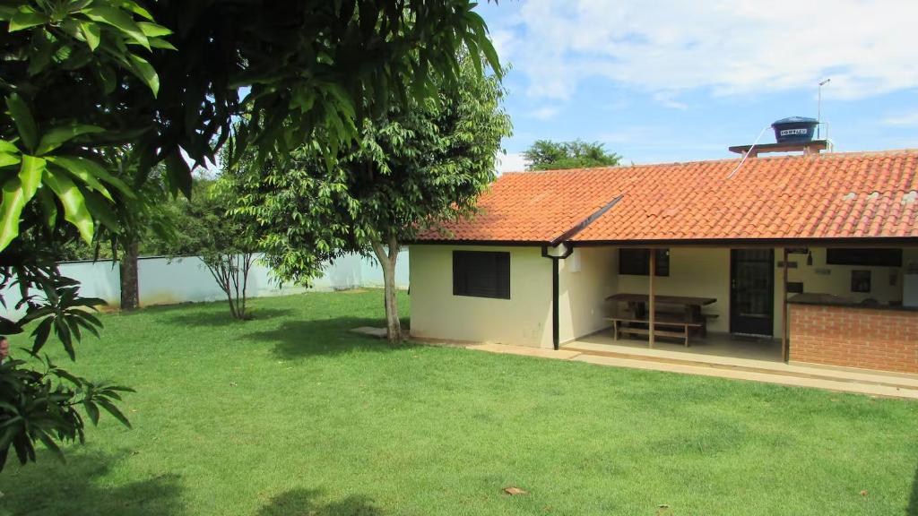 une maison avec une cour verdoyante devant elle dans l'établissement Casinha Charmosa & Rústica, à Indaiatuba