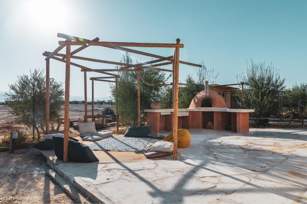 un espace extérieur avec une cheminée et une structure en bois dans l'établissement הבית האנדלוסי, à H̱aẕeva