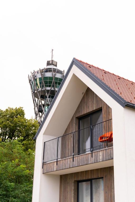 a building with a balcony with a tv tower in the background at Hiša ob stolpu in Lendava