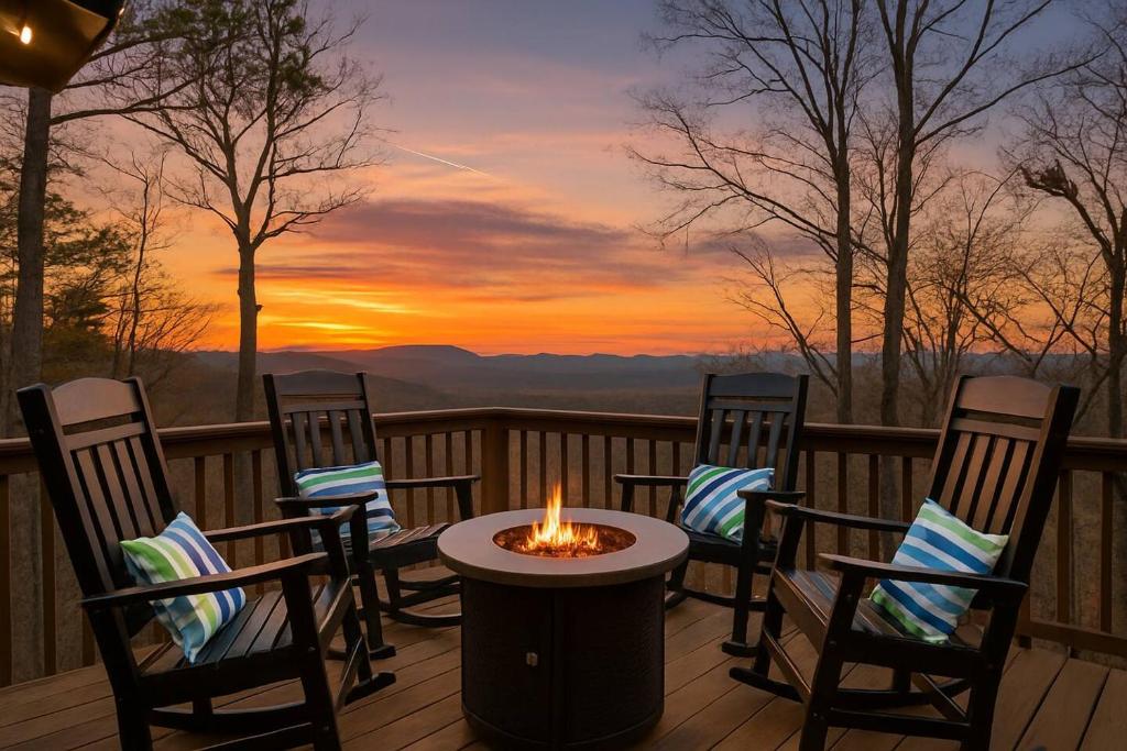 eine Feuerstelle auf einer Terrasse mit Stühlen und ein Sonnenuntergang in der Unterkunft The Fox & Fir Luxe Retreat- Sauna & Cold Plunge in Blue Ridge