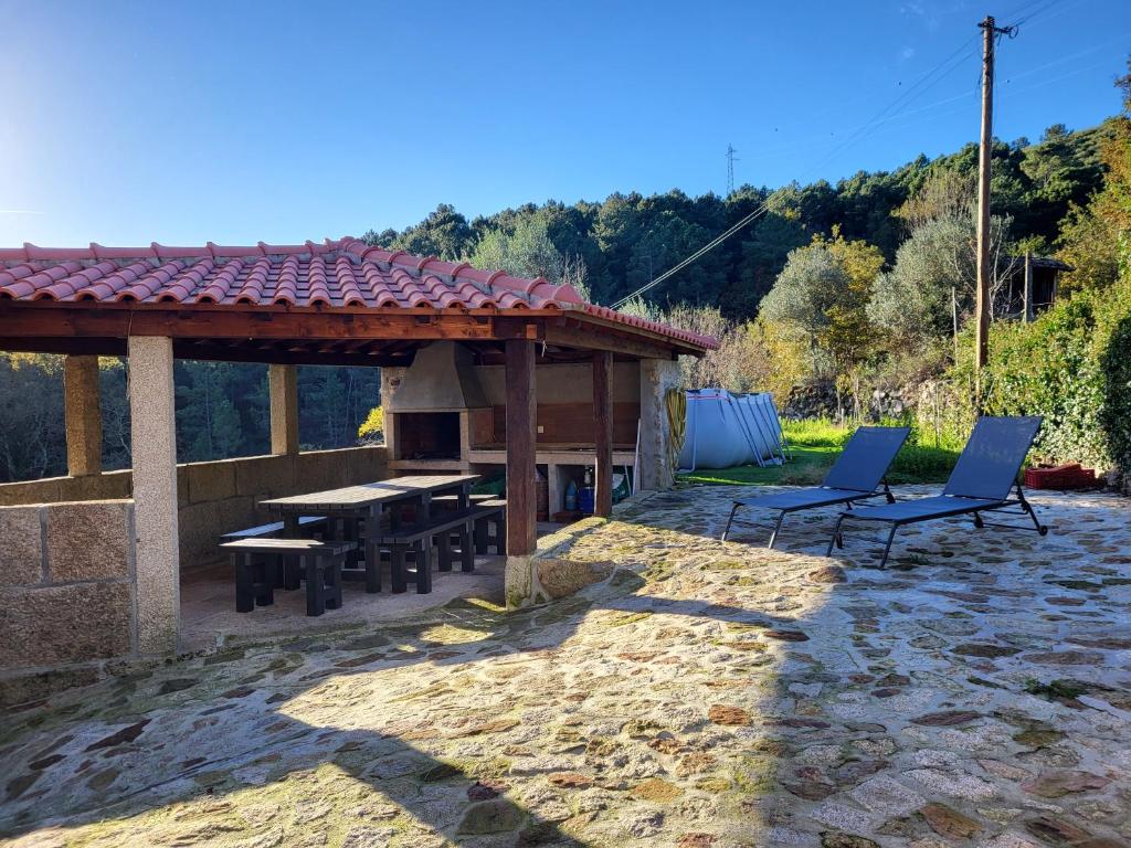 eine Terrasse mit einem Kamin, einem Tisch und Stühlen in der Unterkunft Cantinho do Mourão familiale com terraço e salamandra in Ribeira de Pena
