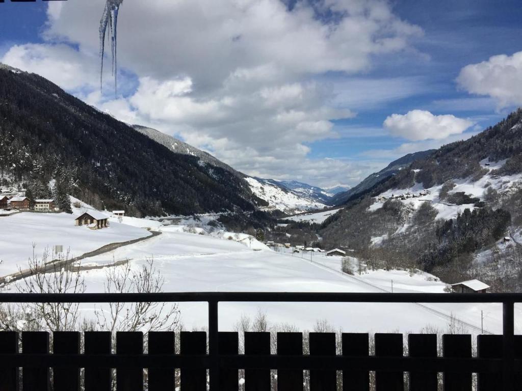 Una vista de un valle cubierto de nieve con montañas. en Gemütliche Ferienwohnung Im Disentiserhof, en Disentis