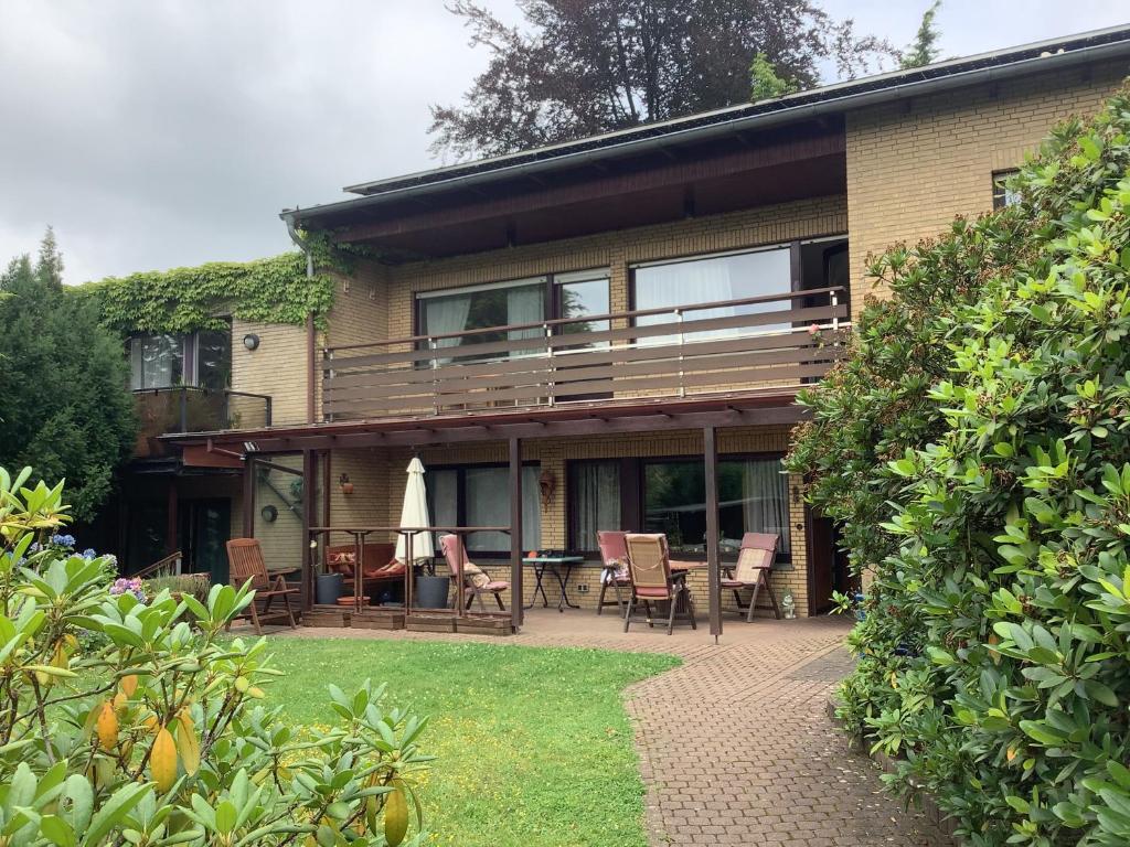ein Haus mit einer Terrasse mit Stühlen und einem Tisch in der Unterkunft Appartements Haus Hashagen in Oerlinghausen