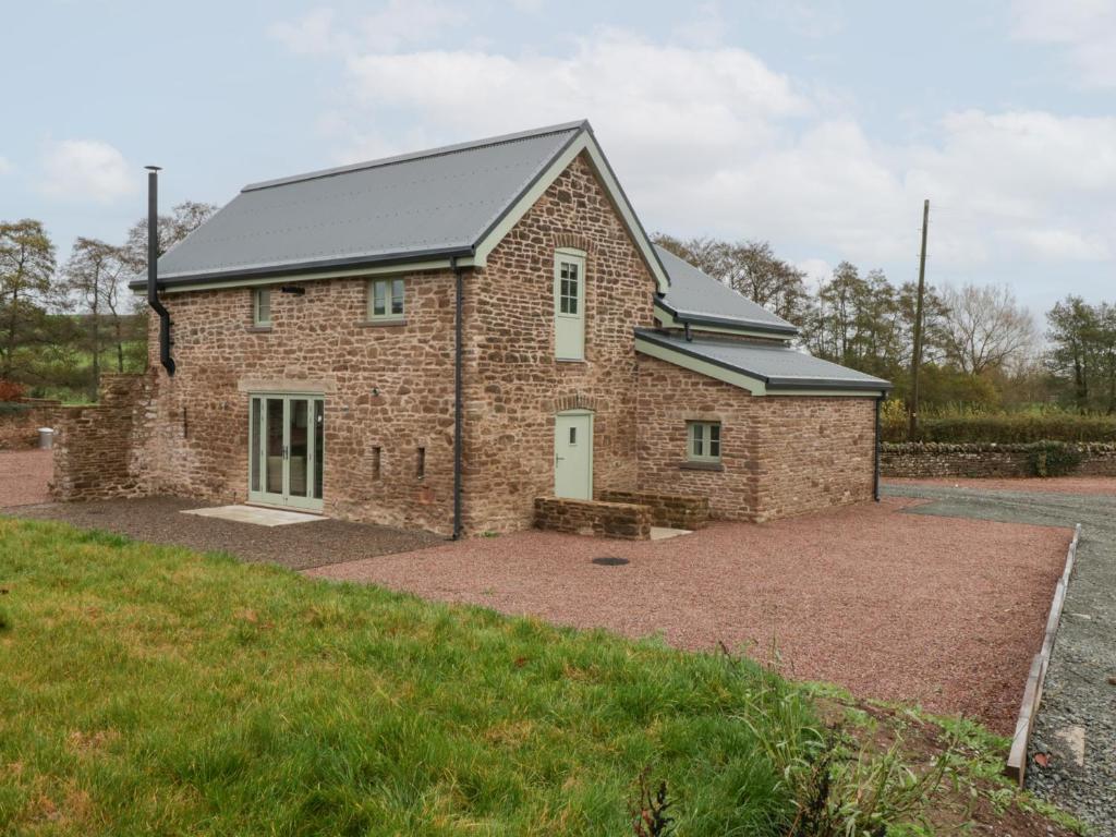 a brick house with a grey roof at Velindra Farm Cottage in Hereford