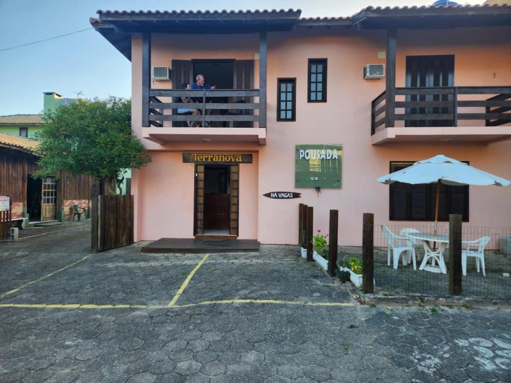 a person standing on the balcony of a house at Pousada Terranova in Garopaba