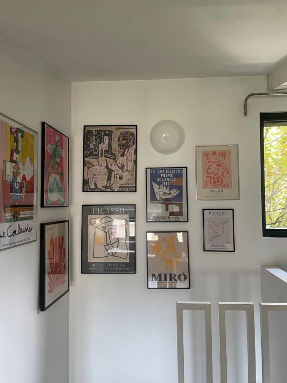 a wall with framed pictures on a white wall at Suite de 35 m2 in Les Lilas
