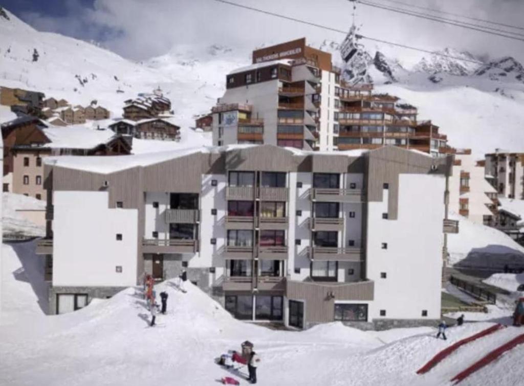 Un groupe de personnes dans la neige devant un bâtiment dans l'établissement Osciere Ski in - Out, à Val Thorens