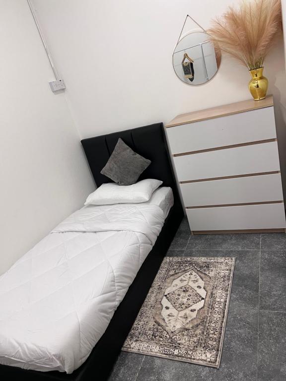 a bedroom with a bed and a dresser and a rug at Davenah Motel Kota Marudu in Kampong Sorosob