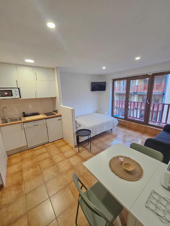 a room with a bed and a kitchen with a table at Kyra-Apartaments FronteraBL HUT2-6074 in Pas de la Casa