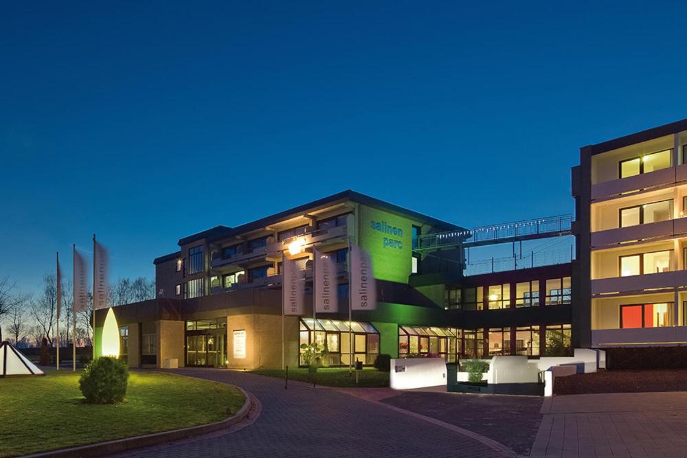 un gran edificio por la noche con sus luces encendidas en salinenparc Design Budget Hotel, en Erwitte