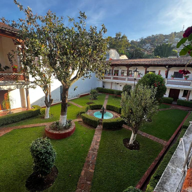 a garden with trees and a fountain in the middle at Hotel Calli Yoloiztac, Valle de bravo in Valle de Bravo