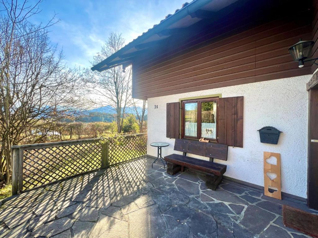 une maison avec un balcon doté d'une fenêtre et d'un banc dans l'établissement Ferienhaus Faulensee, à Rieden