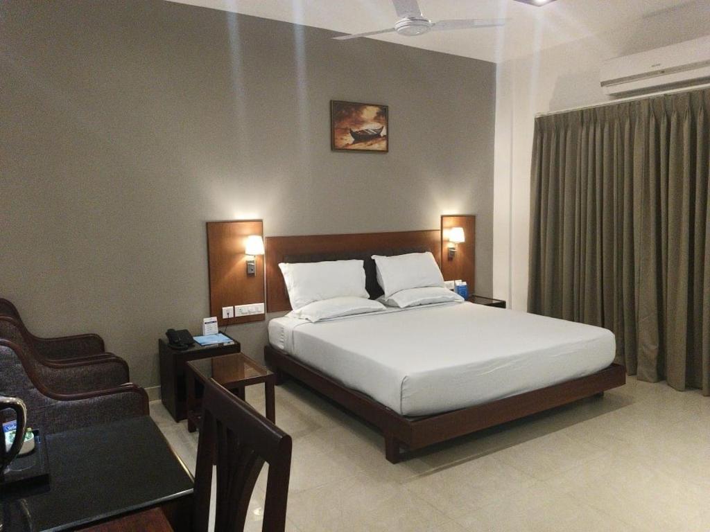 科钦Hotel O Vyttila Bus Station Formerly Astro Tower的一间卧室配有一张床、一把椅子和一张沙发