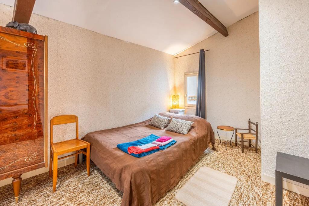 une chambre avec un lit, une table et des chaises dans l'établissement Chambre Songes d'Afrique, à Montournais