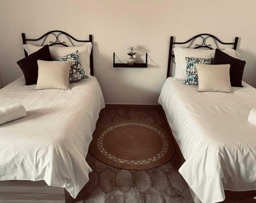 due letti uno accanto all'altro in una stanza di Apartamentos El Paso a Pedrera