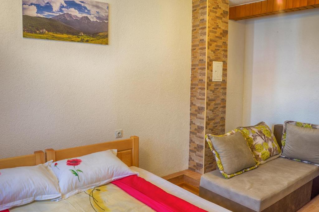 a small bedroom with a bed and a couch at Apartment M in Žabljak