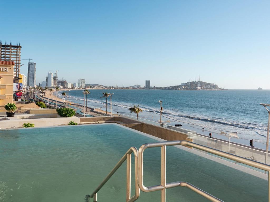 una piscina con spiaggia sullo sfondo di De lujo Con vista al mar en el Malecon a Mazatlán