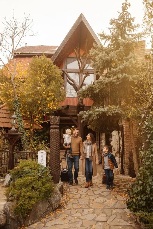 un grupo de personas caminando frente a una casa en Hotel Barbizon, en Nyíregyháza
