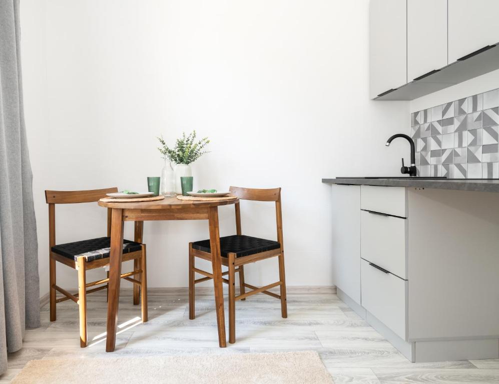 eine Küche mit einem Holztisch und Stühlen in der Unterkunft Nowoczesne Studio Mała Andrzeja, Kawalerka Inowrocław, Modern Studio, kamienica in Inowrocław