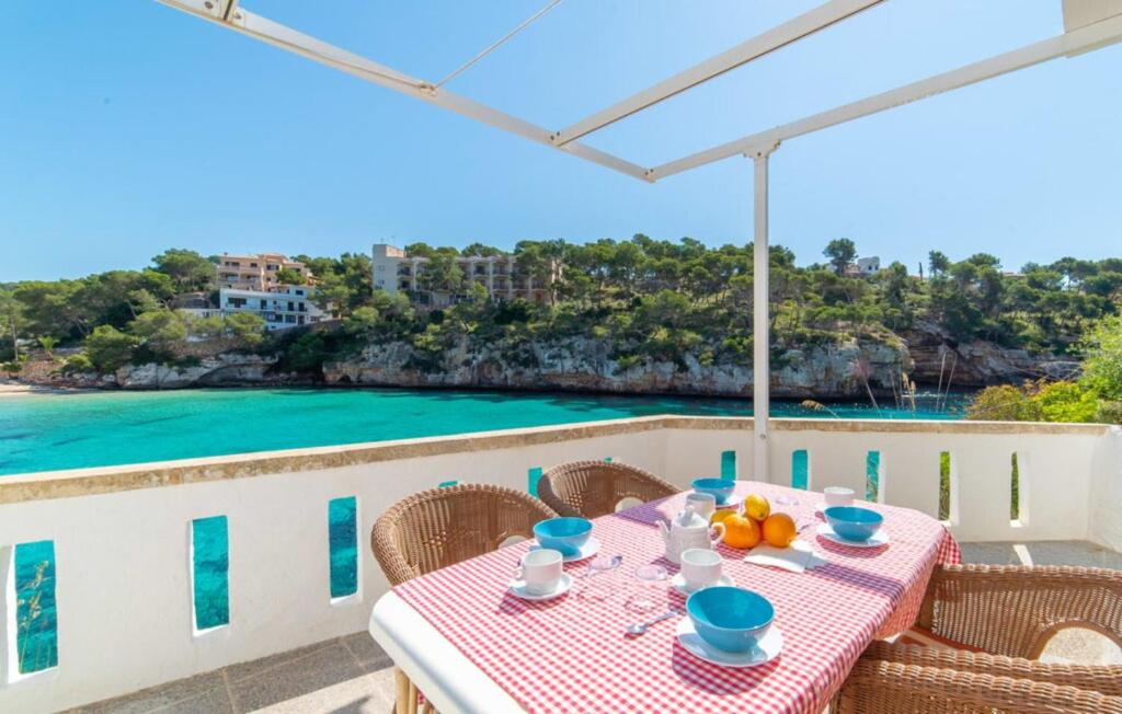 a table on a balcony with a view of the ocean at Sa Barca - Can Ferrando in Cala Santanyi