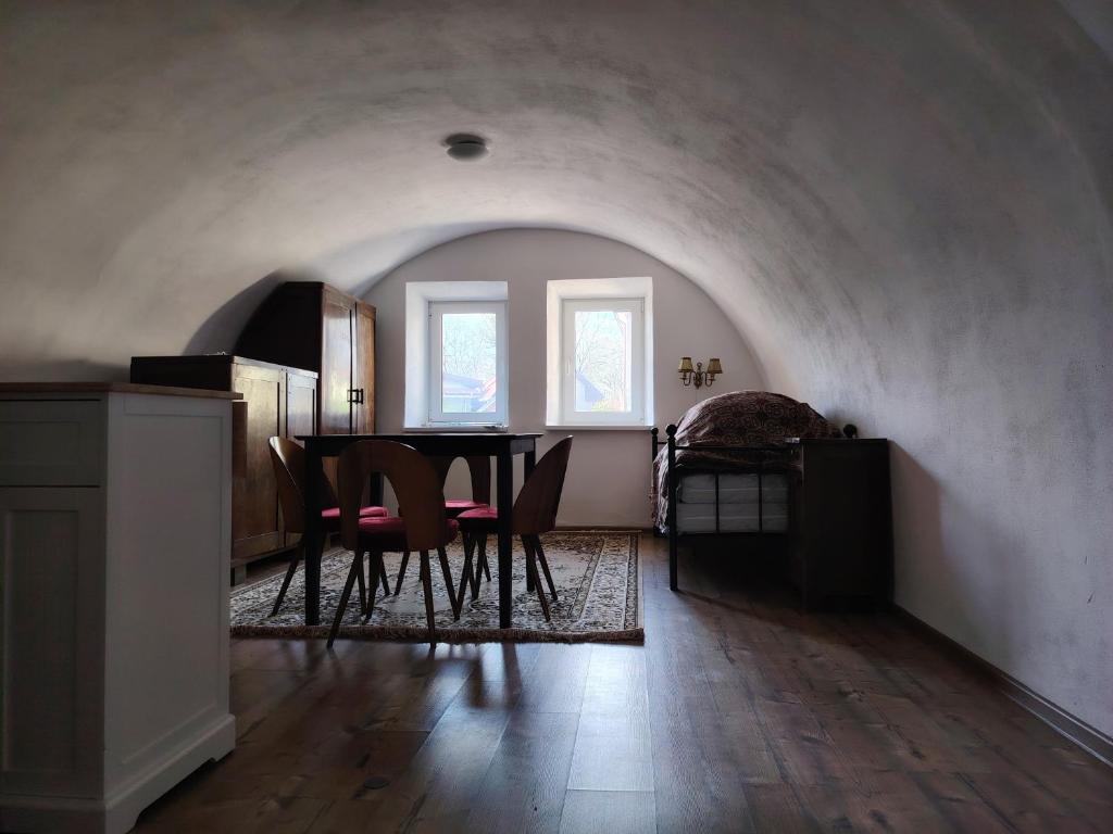 a dining room with a table and chairs in a room at Tichá chalupa in Liptovský Hrádok