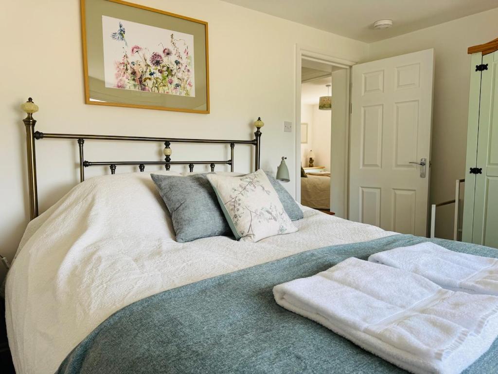 a bedroom with a bed with a towel on it at Wild Spa Cottage in Southwater