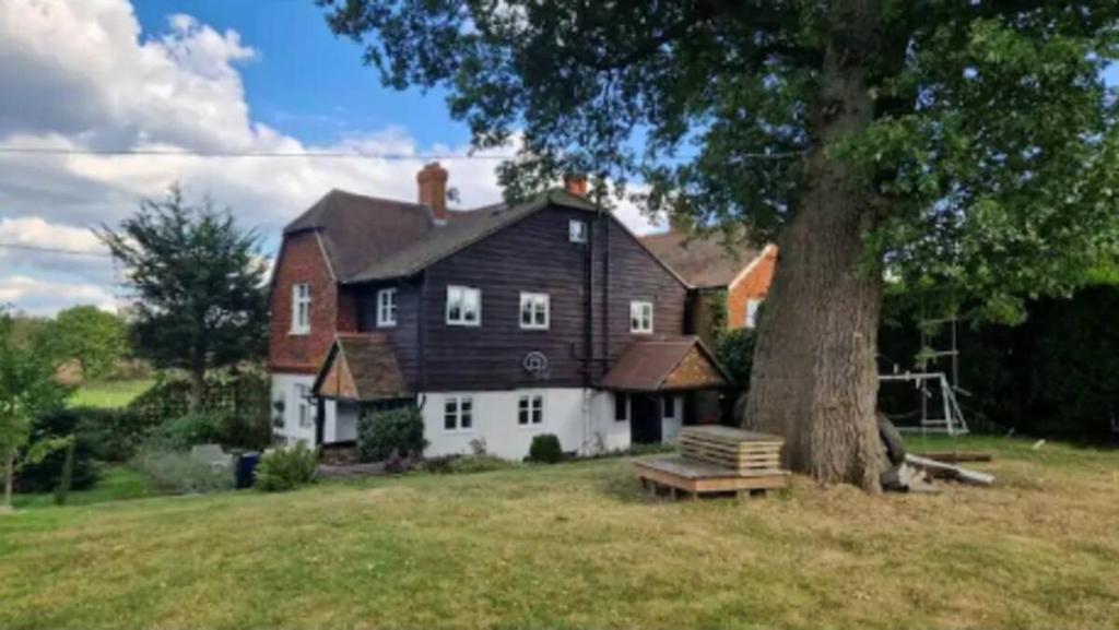 a large house with a tree in front of it at Lavender Cottage in Chertsey