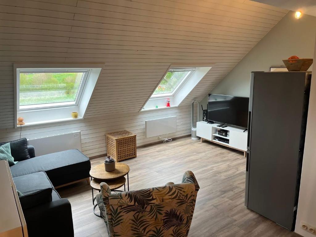 Una sala de estar con un sofá y un televisor en Chez Fernand, en Hotton