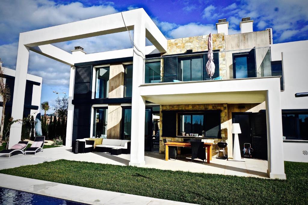 a large white house with chairs and a table at Ferienhaus In Manacor Mit Eigenem Pool in Cala Murada