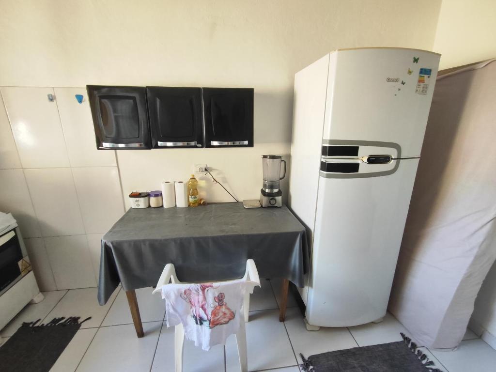 une petite cuisine avec une table et un réfrigérateur dans l'établissement Casa completa na Enseada, Guarujá, à Guarujá