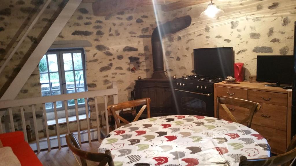 a dining room with a table and a stove at Maison du pâtre in Urbanya