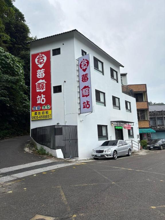 a white building with signs on the side of it at Strawberry Station in Dahu